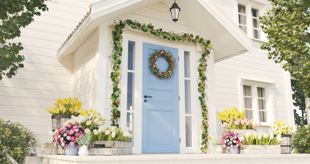 White home with a blue front door and spring wreath